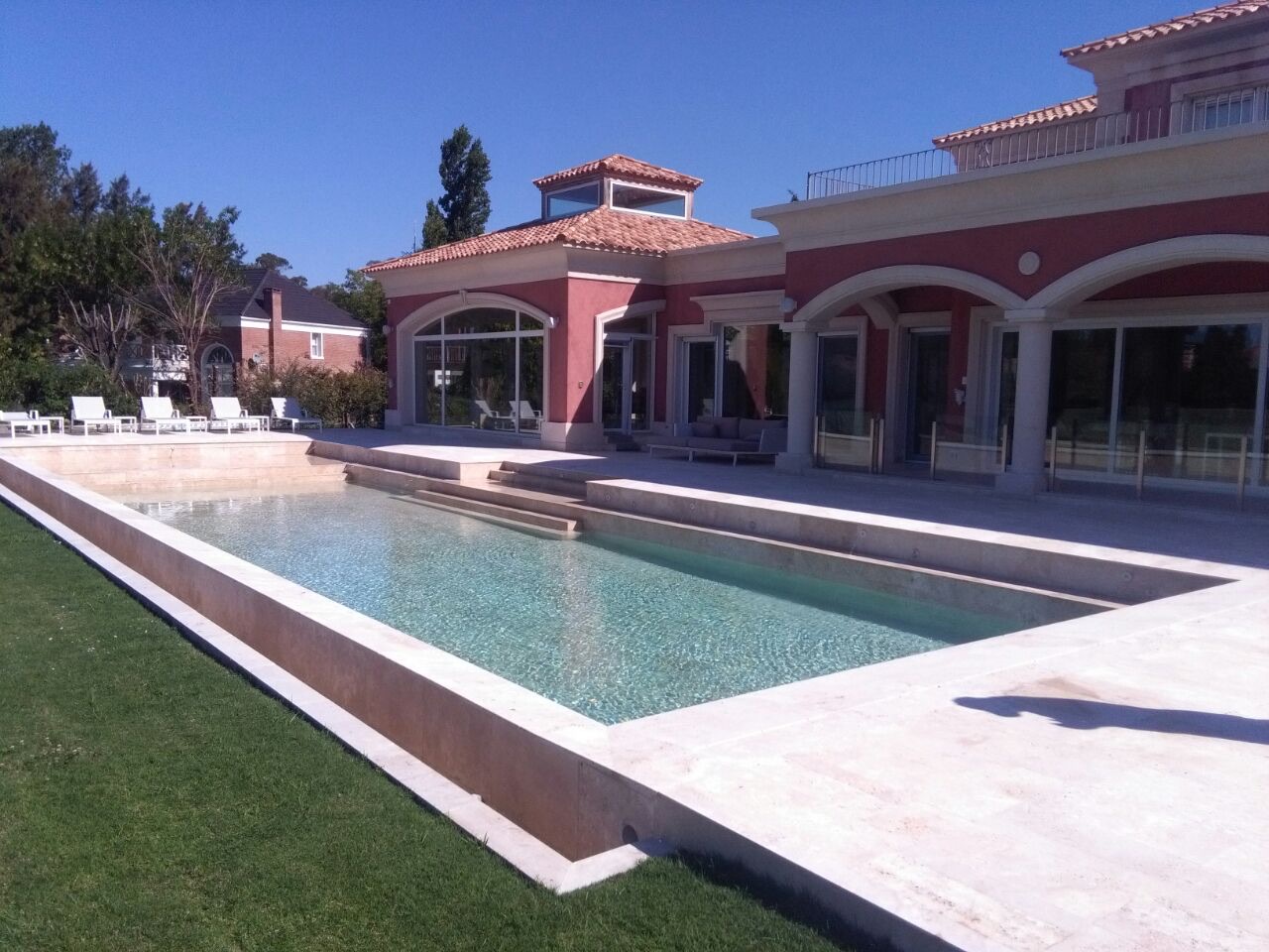 Piscina y solárium revestidos en mármol travertino, Country Club Abril, Hudson