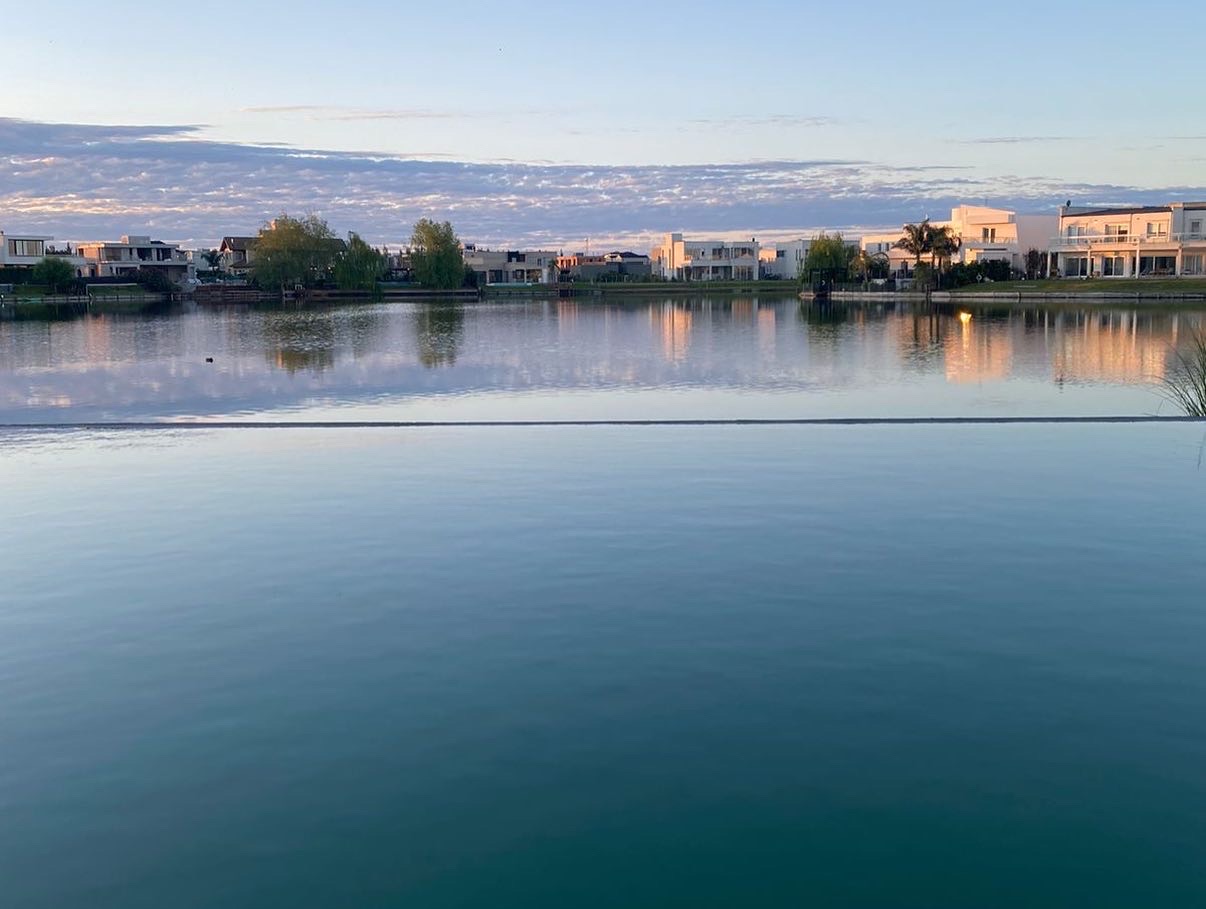 Piscina con desborde infinito perfecto fundido visualmente con el lago