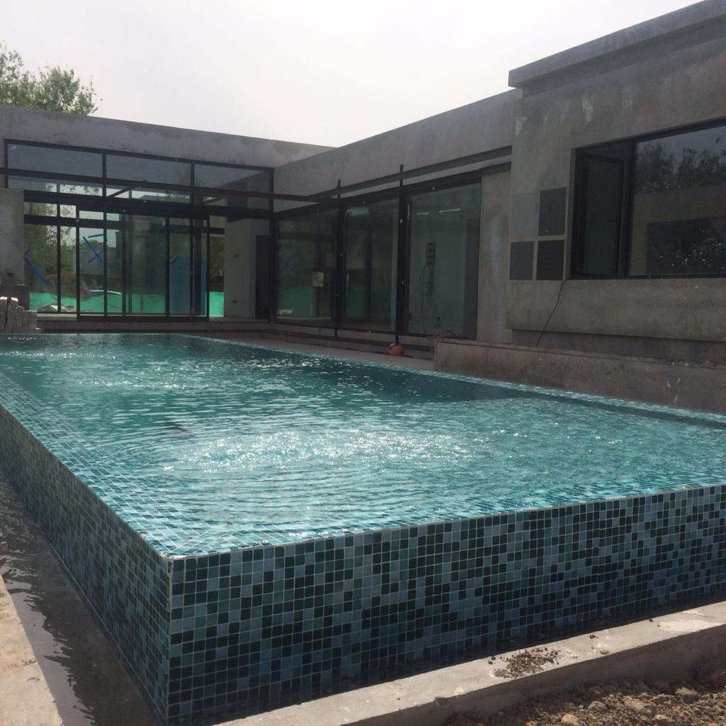 Piscina con desborde infinito integral en todo el perímetro, revestimiento en venecitas