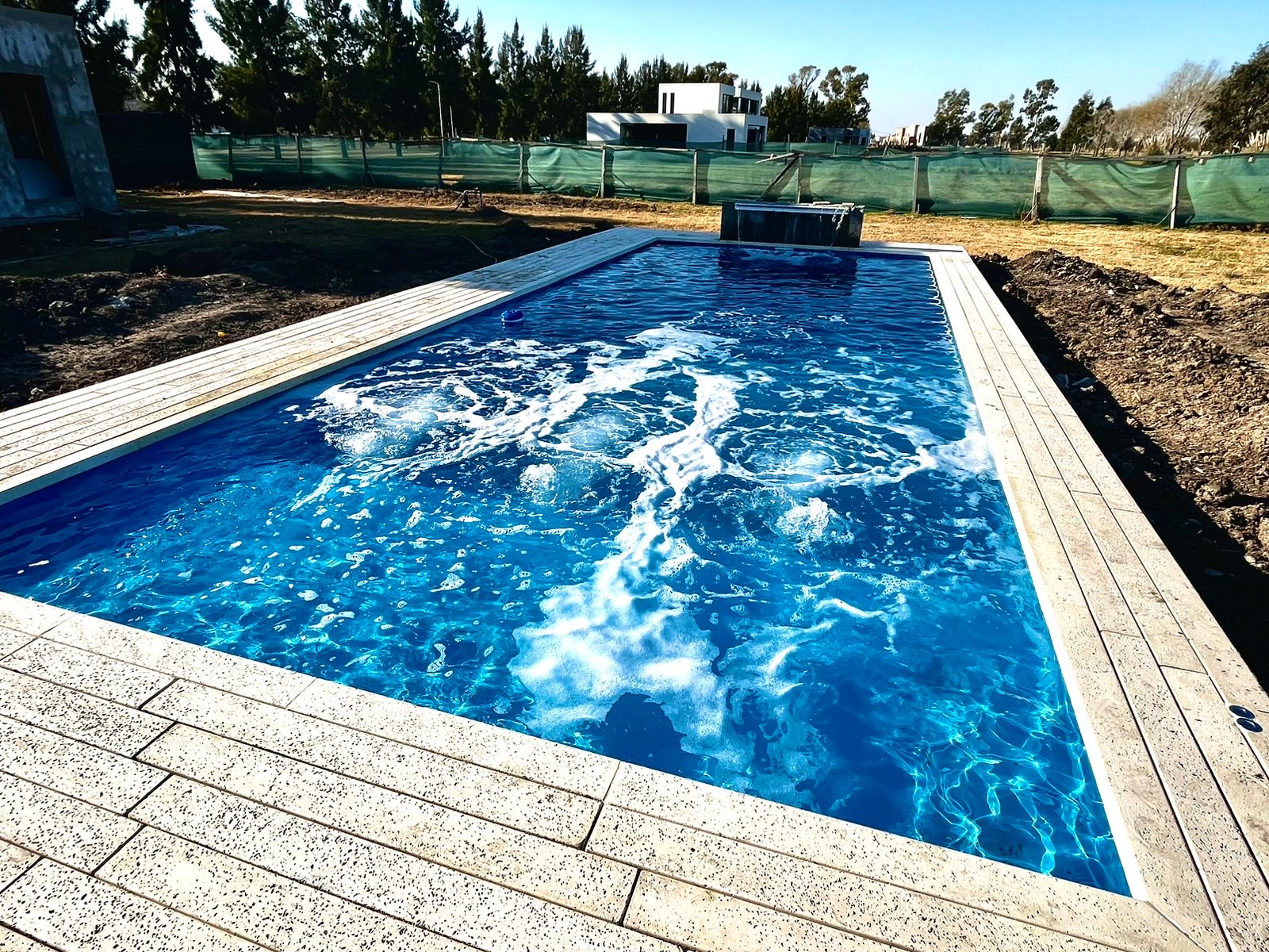 Piscina en Aquavation celeste con cascada de piedra integrada, Haras del Sur 2