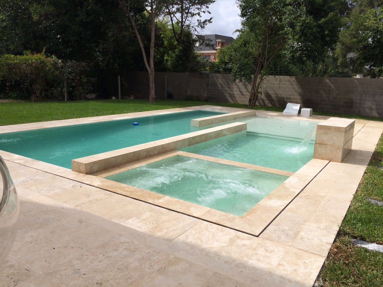 Piscina y solárium en mármol travertino con jacuzzi integrado y cascada, Hudson
