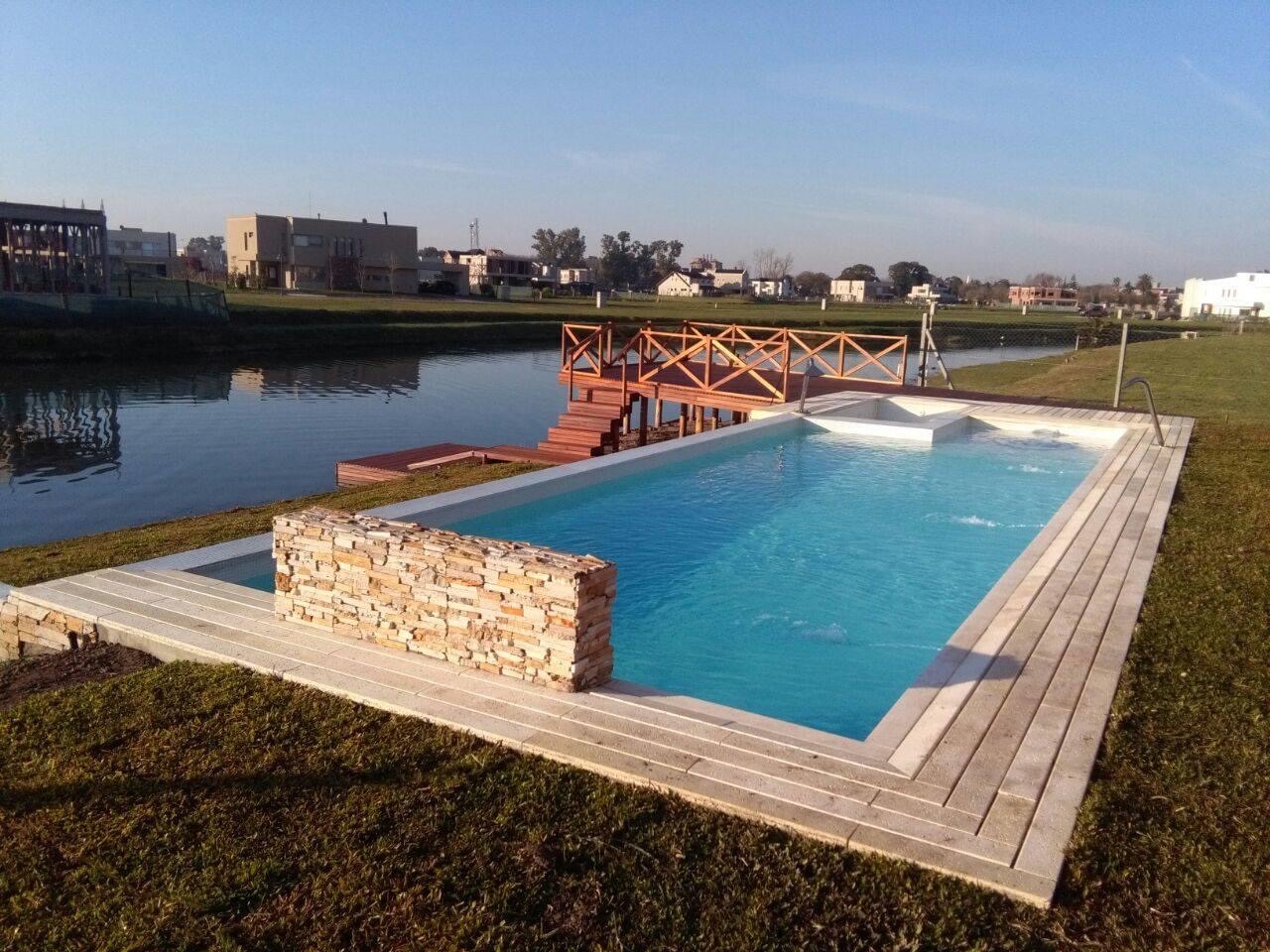 Piscina con vista al lago, muelle y solárium en listón de deck, Nuevo Quilmes