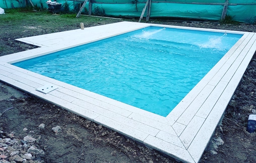 Piscina compacta con venecitas blancas y banco de hidromasaje integrado