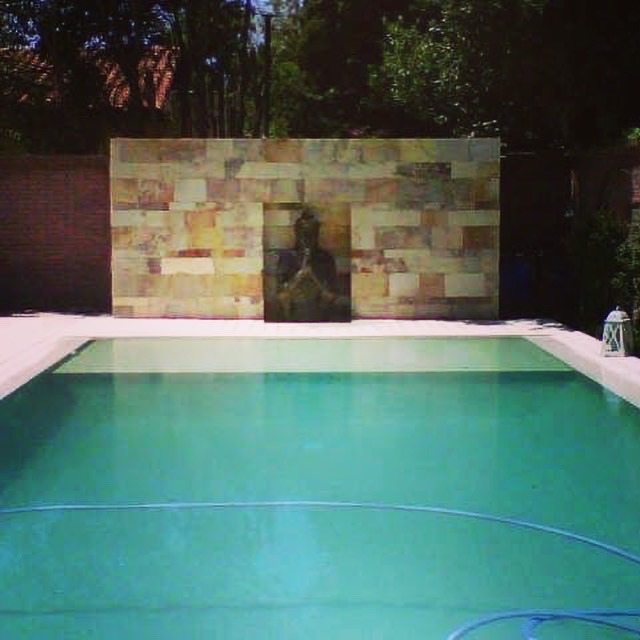 Piscina y jacuzzi integrados en jardín zen con mármol travertino